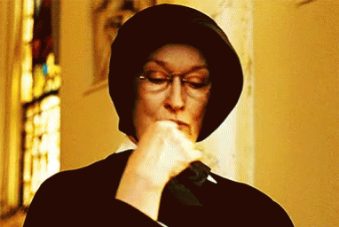 Woman Wearing Glasses And Hat Holding Knife In Mouth GIF