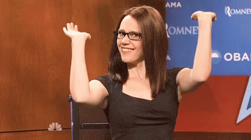 Woman Wearing Glasses Sitting In Front Of Oma Sign GIF