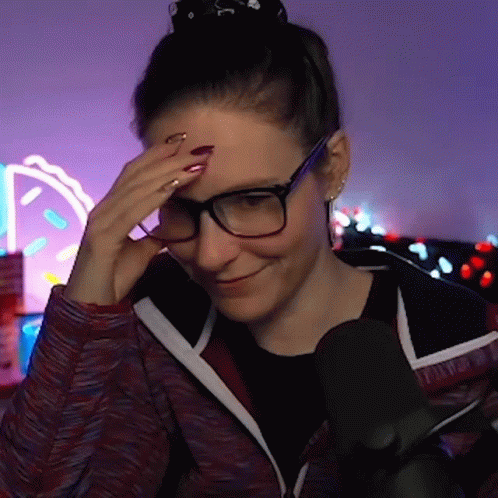 Woman Wearing Glasses Smiling and Holding Forehead