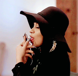 Woman Wearing Hat Licking Fingers