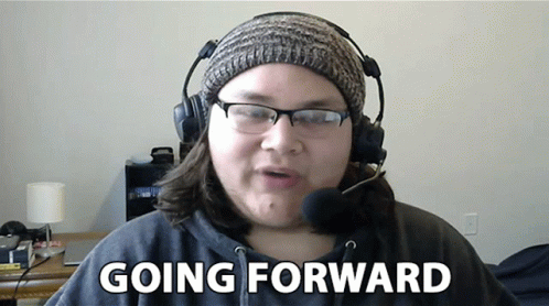 Woman Wearing Headphones and Beanie Says Going Forward