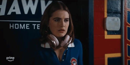 Woman Wearing Headphones in Front of Awks Sign