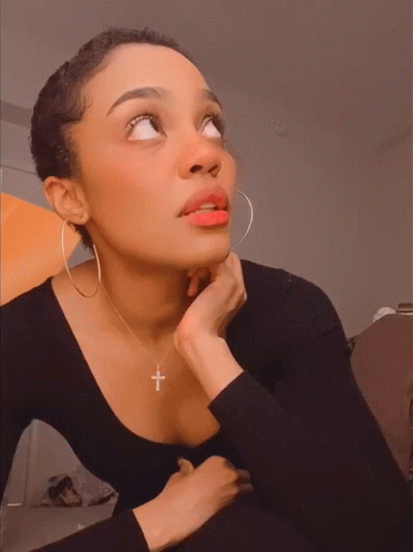 Woman Wearing Hoop Earrings and Cross Necklace Looking Up