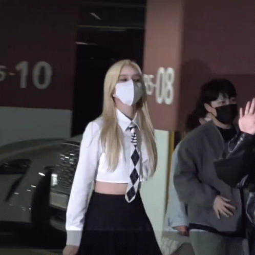 Woman Wearing Mask in Front of Parking Garage