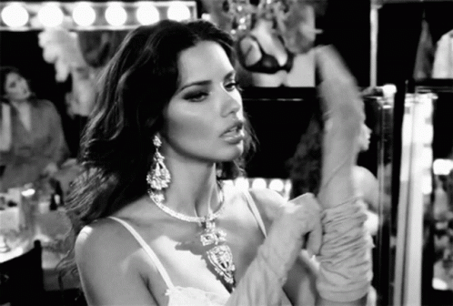 Woman Wearing Necklace and Gloves Looking in Mirror