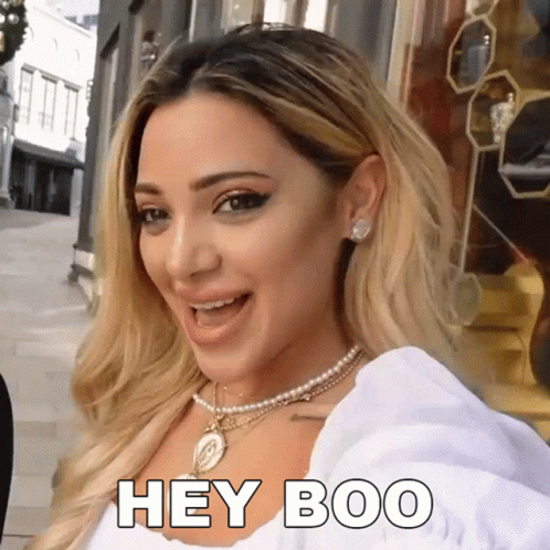 Woman Wearing Pearl Necklace and Earrings Says Hey Boo