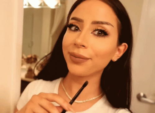 Woman Wearing Pearl Necklace Holding Brush GIF