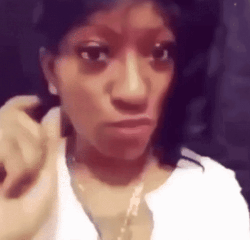Woman Wearing White Shirt and Gold Necklace Making Face