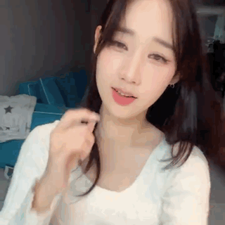 Woman White Shirt Holding Hair Looking at Camera