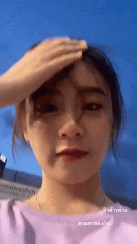 Woman Wiping Forehead in Pink Top