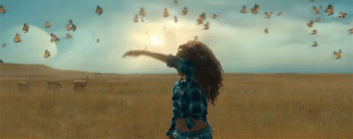 Woman With Arms Outstretched Surrounded by Butterflies