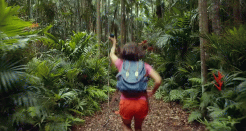 Woman With Backpack Walking Through Jungle GIF