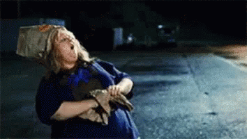 Woman With Bag On Head Standing By Road GIF