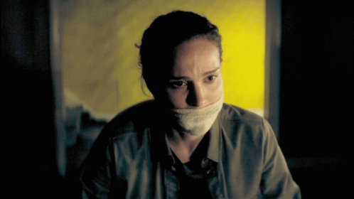 Woman With Bandage Around Mouth Looking At Camera GIF
