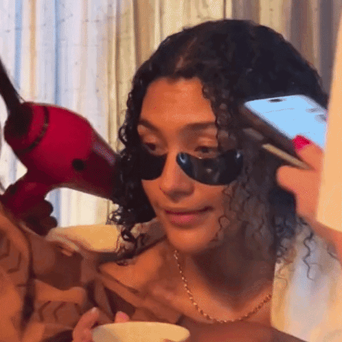 Woman With Black Eye Patches Holding Phone GIF