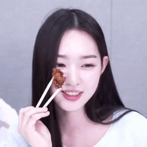 Woman with Black Hair Eating Meat with Chopsticks