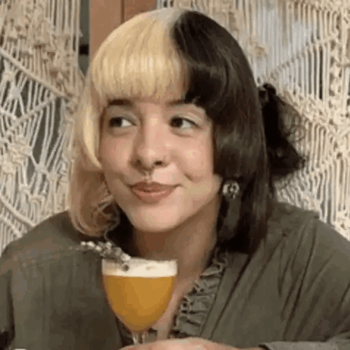 Woman With Blonde and Black Hair Smiling Holding Beer