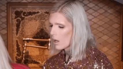 Woman With Blonde Hair In Front Of Fireplace GIF