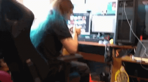 Woman With Blue Hair Sitting At Desk With Computer