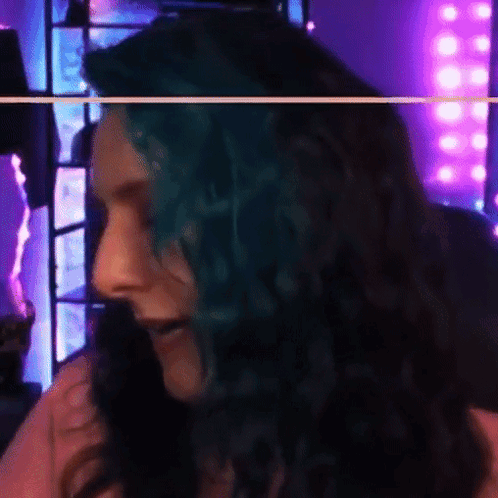 Woman With Blue Hair Smiling In Front Of Purple Background GIF