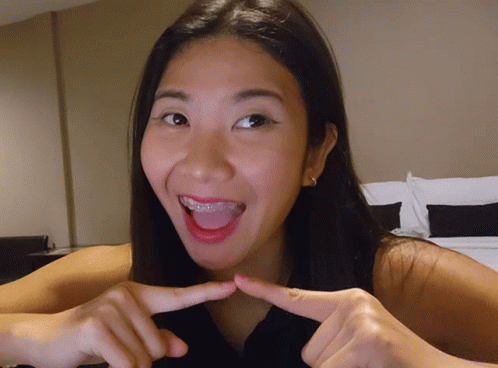 Woman With Braces Making Finger Heart
