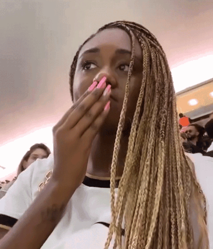 Woman With Braids And Pink Nails Covering Mouth GIF