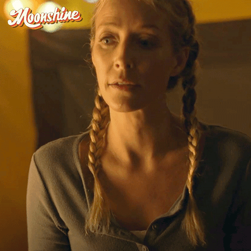 Woman with Braids Saying Its True in Front of Moonshine Logo