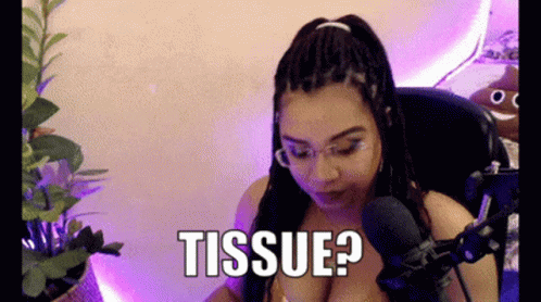 Woman With Braids Sitting at Microphone Saying Tissue