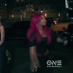 Woman With Bright Pink Hair Standing in Front of Pay Here Sign