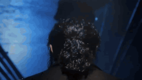 Woman with Bun Standing in Dark Room