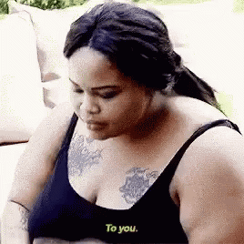 Woman With Chest Tattoo Sitting on Couch
