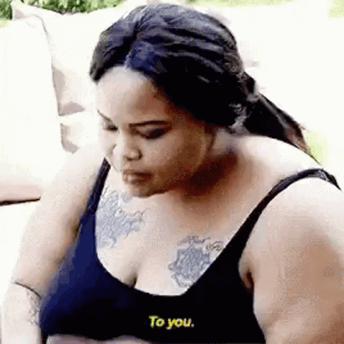 Woman With Chest Tattoo Talking on Couch