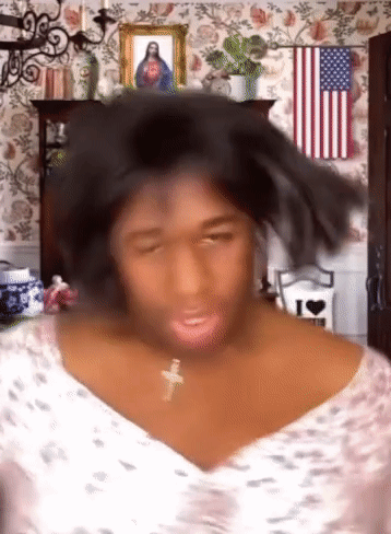Woman With Cross Necklace in Front of American Flag and Jesus Picture