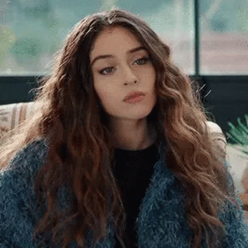 Woman with Curly Hair and Blue Fur Coat on Couch