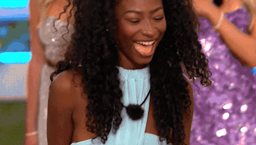 Woman With Curly Hair And Blue Top Smiling GIF