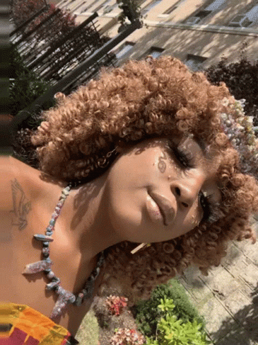 Woman With Curly Hair and Chest Tattoo