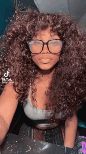 Woman With Curly Hair and Glasses in Crop Top and White Tank Top