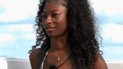 Woman With Curly Hair And Necklace Smiling GIF