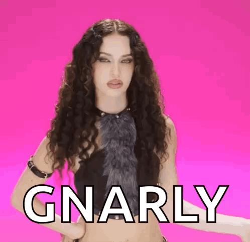 Woman With Curly Hair In Front Of Pink Background With Gnarly GIF