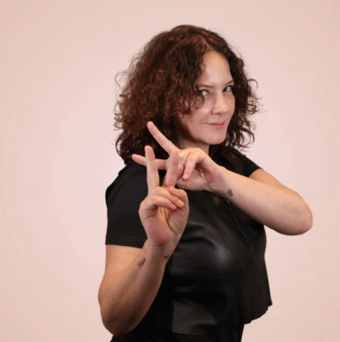 Woman With Curly Hair In Leather Top And Rosary GIF