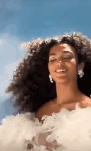 Woman With Curly Hair In White Dress Smiling Eyes Closed GIF