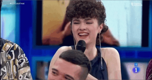 Woman With Curly Hair Laughing at Microphone on TV Show