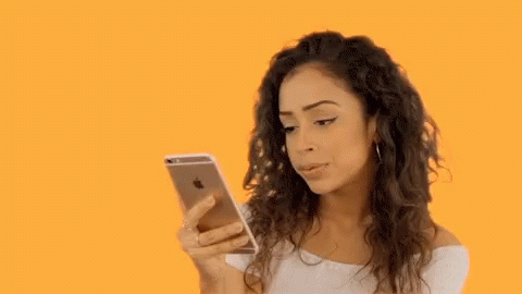 Woman With Curly Hair Looking at Cell Phone