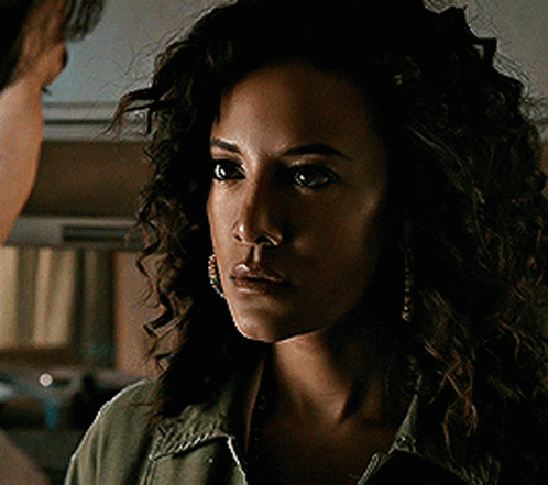 Woman With Curly Hair Looks at Man