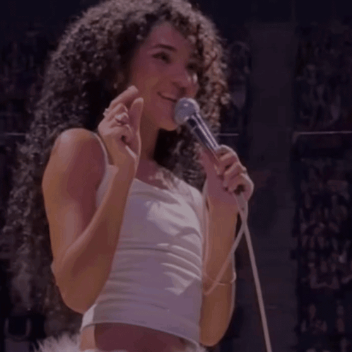 Woman With Curly Hair Singing Into Microphone GIF