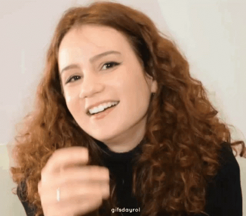 Woman With Curly Hair Smiling and Pointing