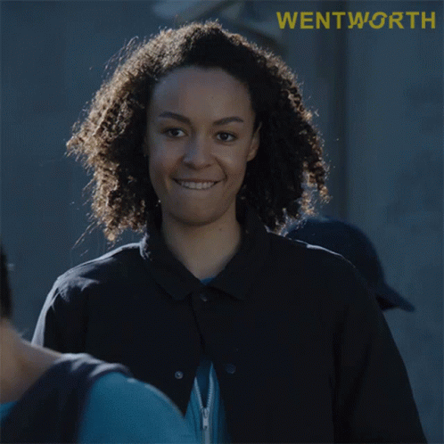 Woman With Curly Hair Smiling at Wentworth Sign