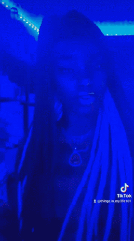 Woman With Dreadlocks in Dark Room With Blue Lights