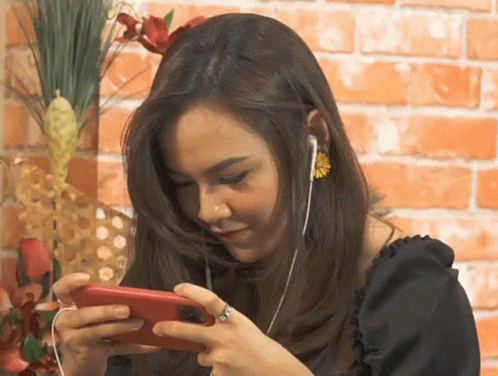 Woman With Ear Buds and Ring Looking at Phone
