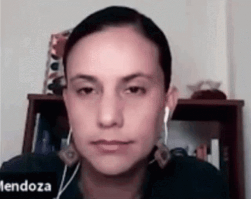 Woman With Ear Buds Looking At Camera GIF